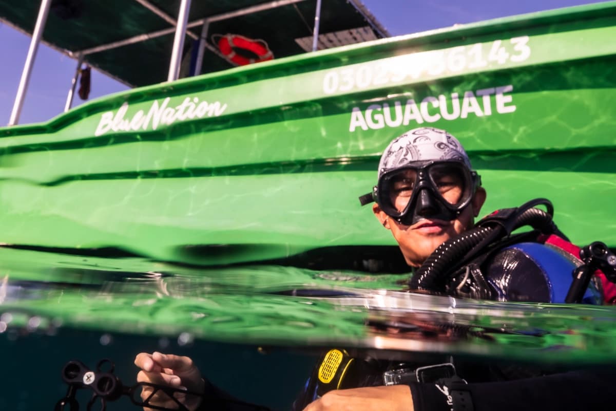 Diver in vibrant turquoise waters near a boat