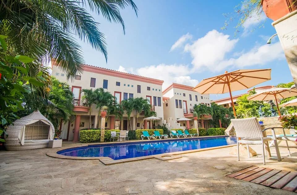 Resort buildings around a swimming pool at Las Sirenas by Mayan Princess Roatan